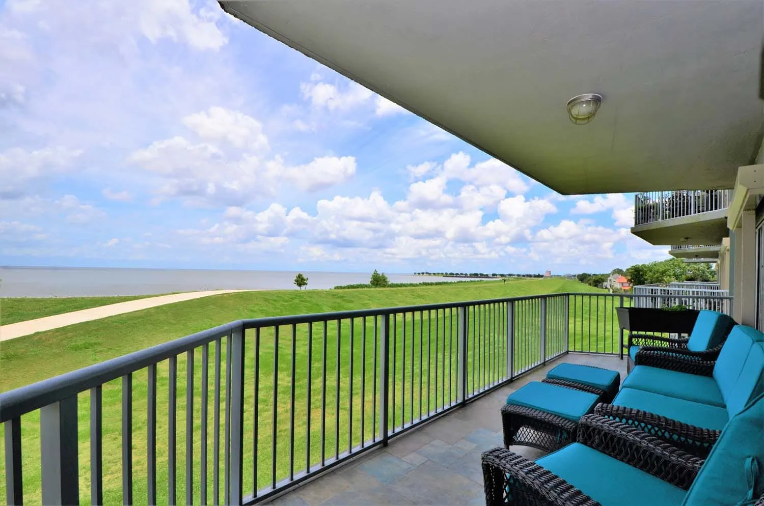 Covered balcony with chaise lounges overlooking the water