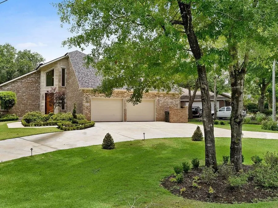 Driveway and two-car garage under mature trees
