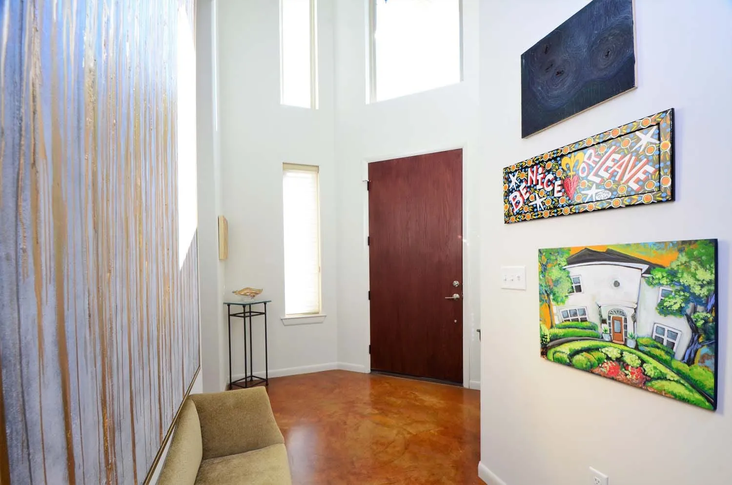 Entry hall with polished concrete floors and original paintings