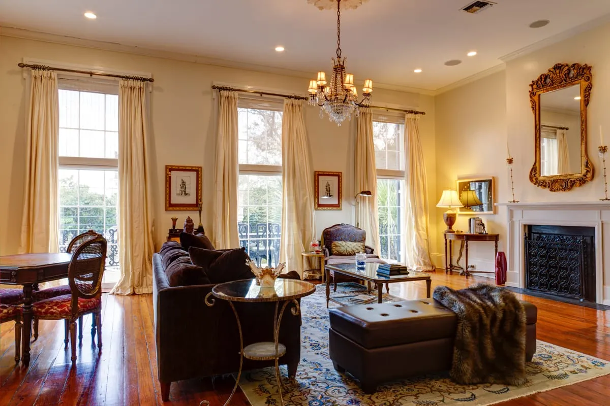 Living room with fireplace, gilt mirror, chandelier and custom furnishings
