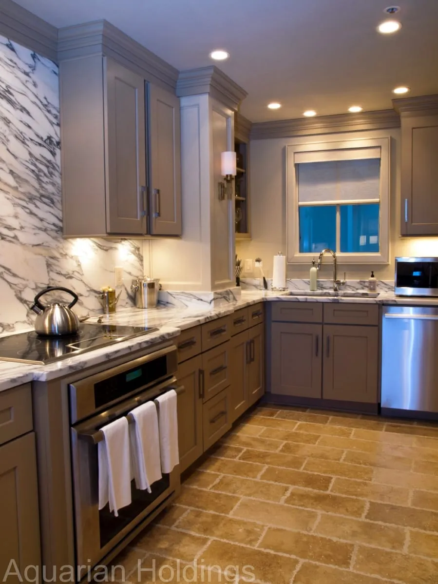 Marble kitchen with stainless appliances and a window over the sink