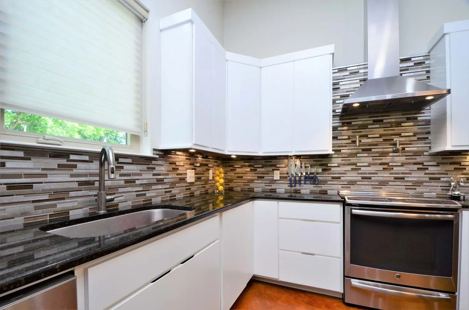 Kitchen with black granite counters and stainless range