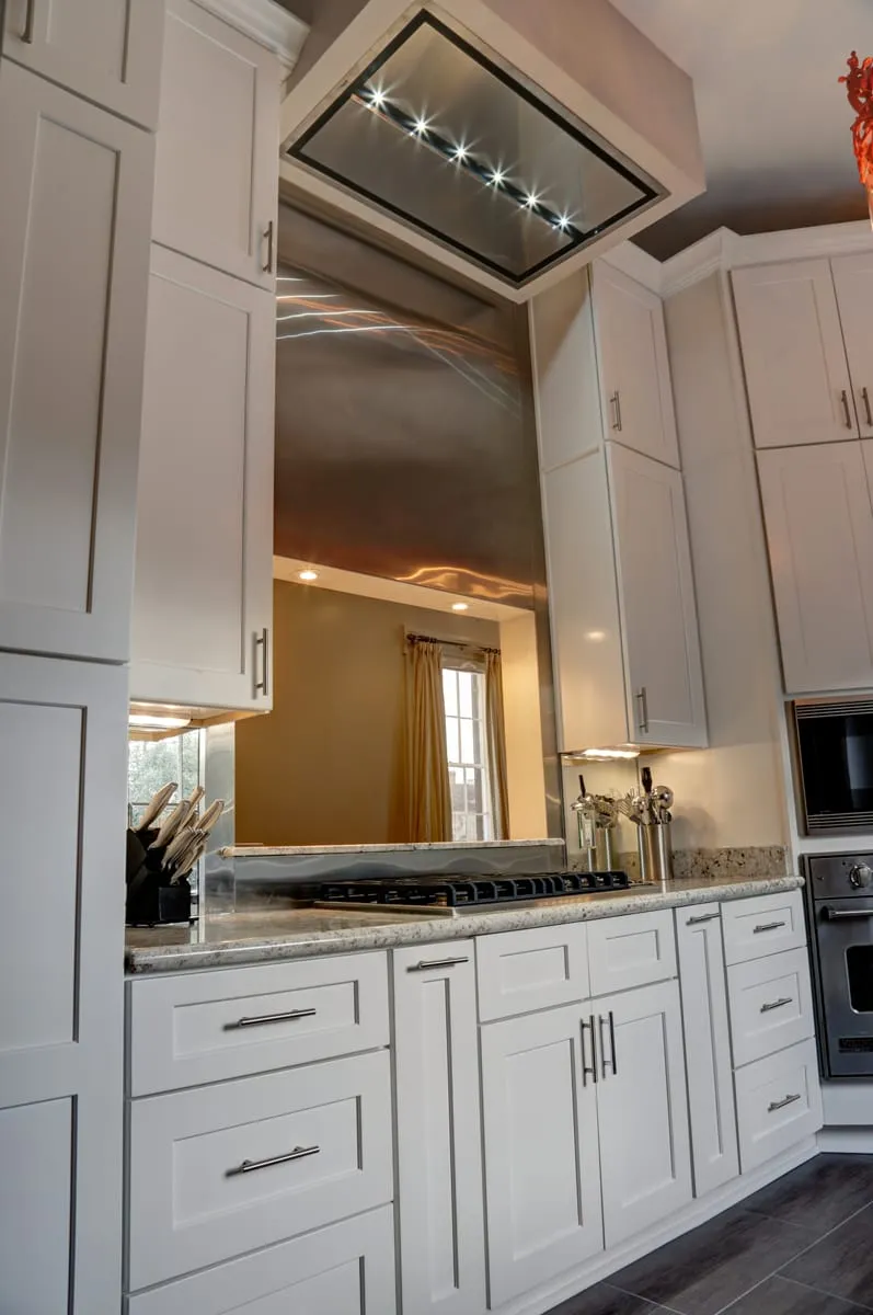 Galley kitchen with white cabinetry and granite counters