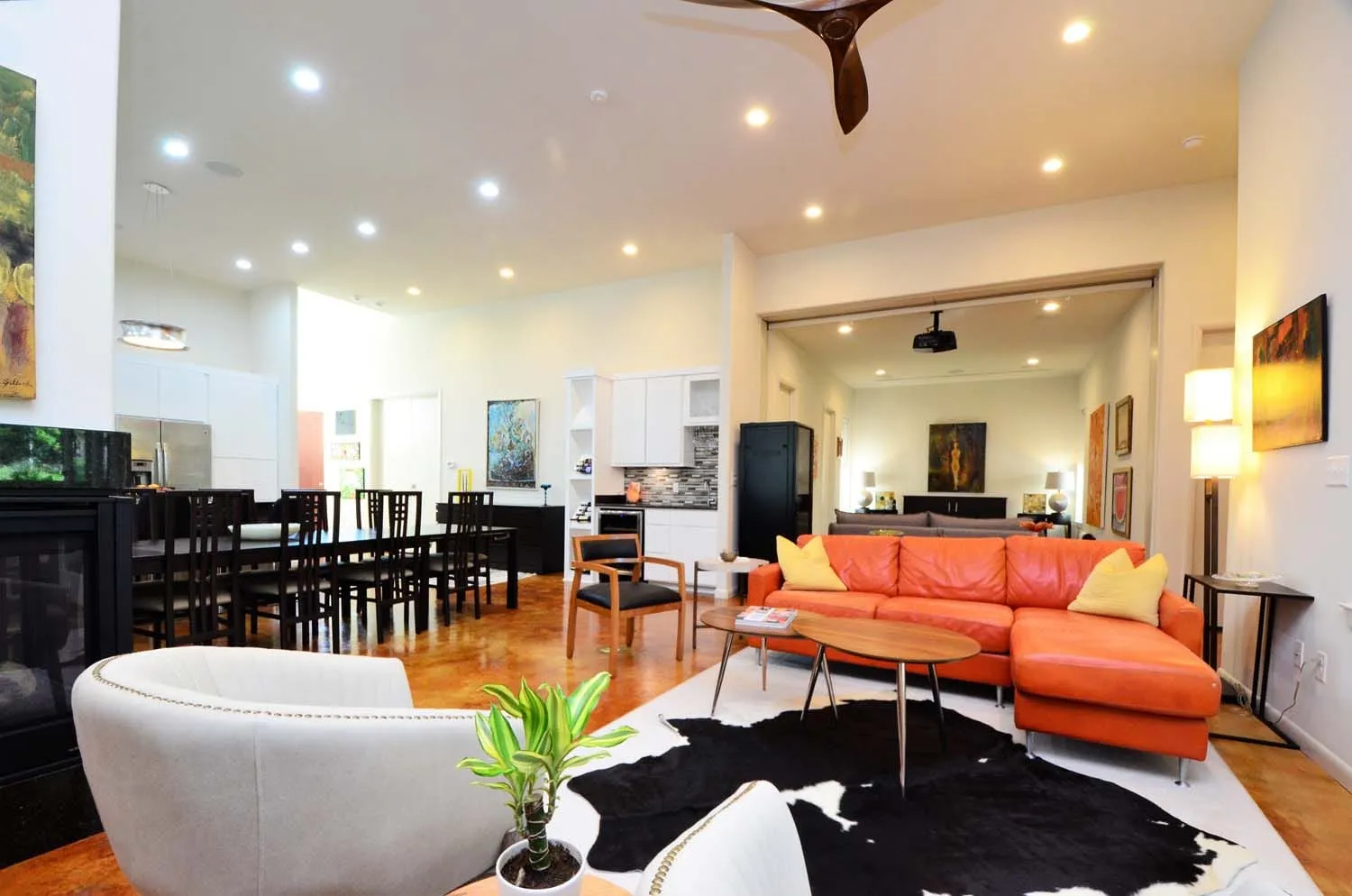 Open living space with orange sectional, cowhide rug and breakfast bar