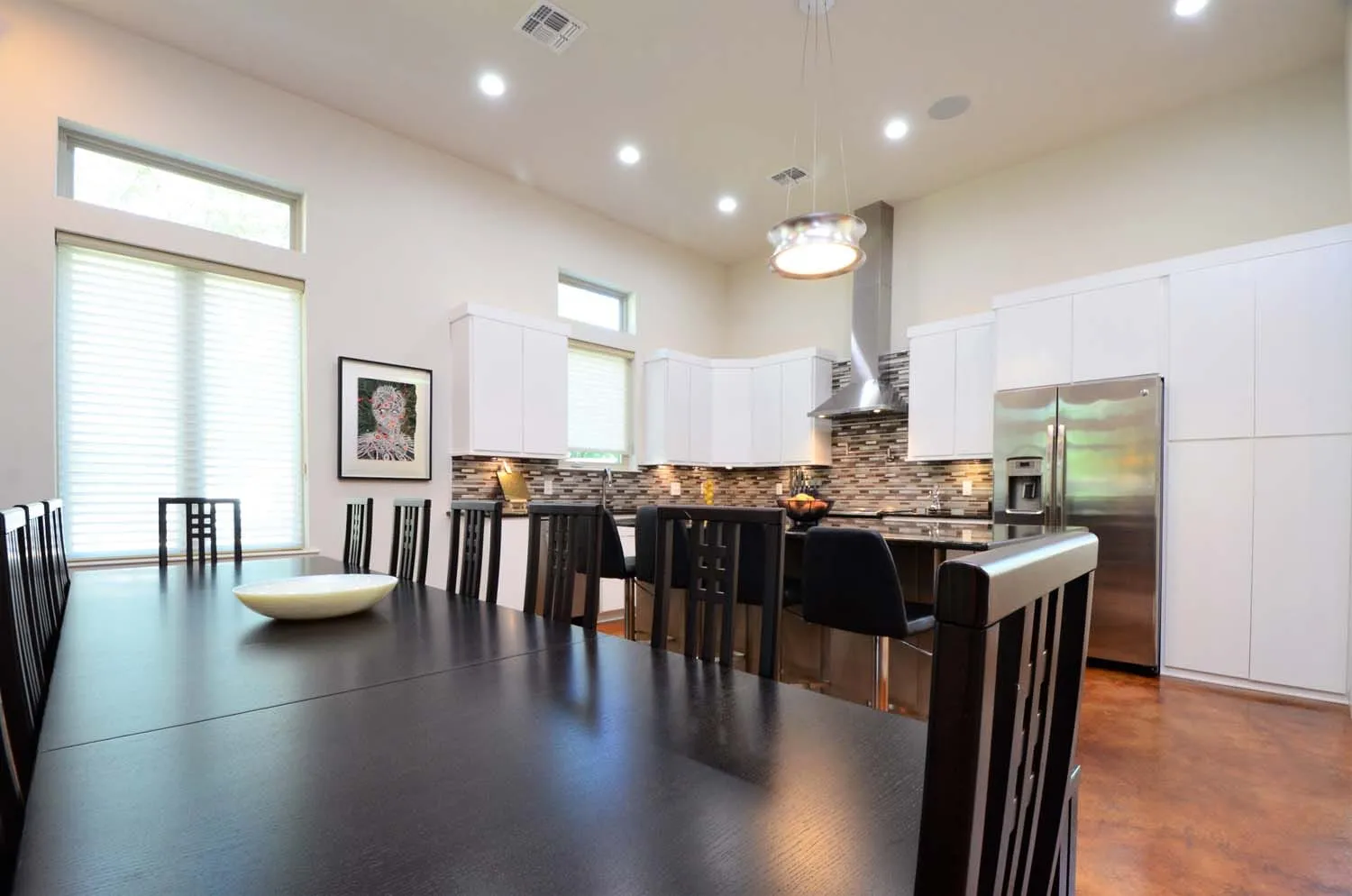 Dining table beside the kitchen under recessed lighting