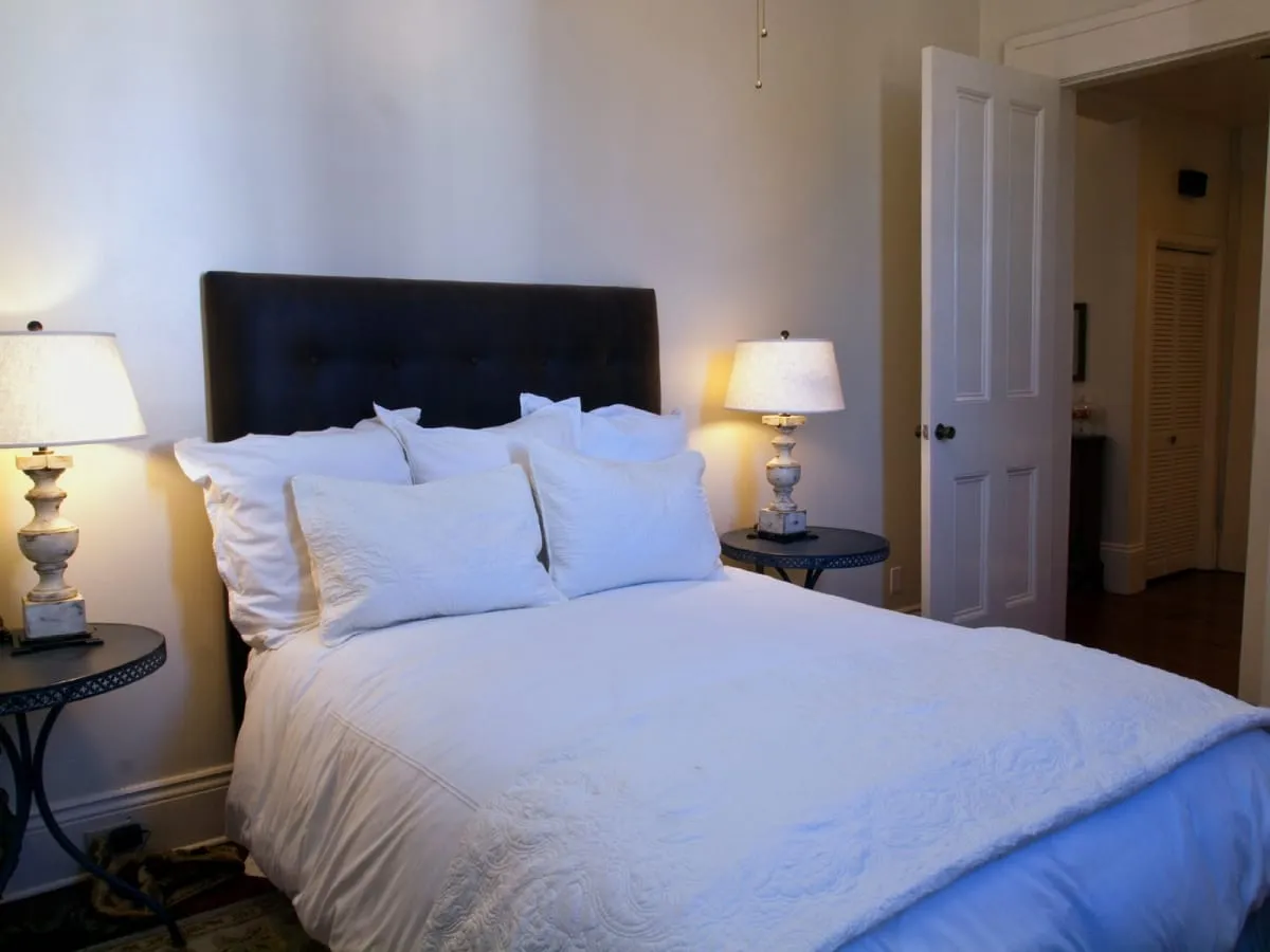 Queen bedroom with upholstered headboard and crisp white linens