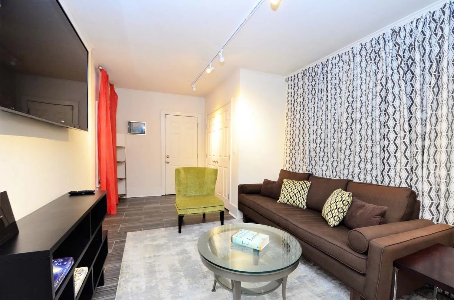 Den with sofa, TV and patterned curtain wall