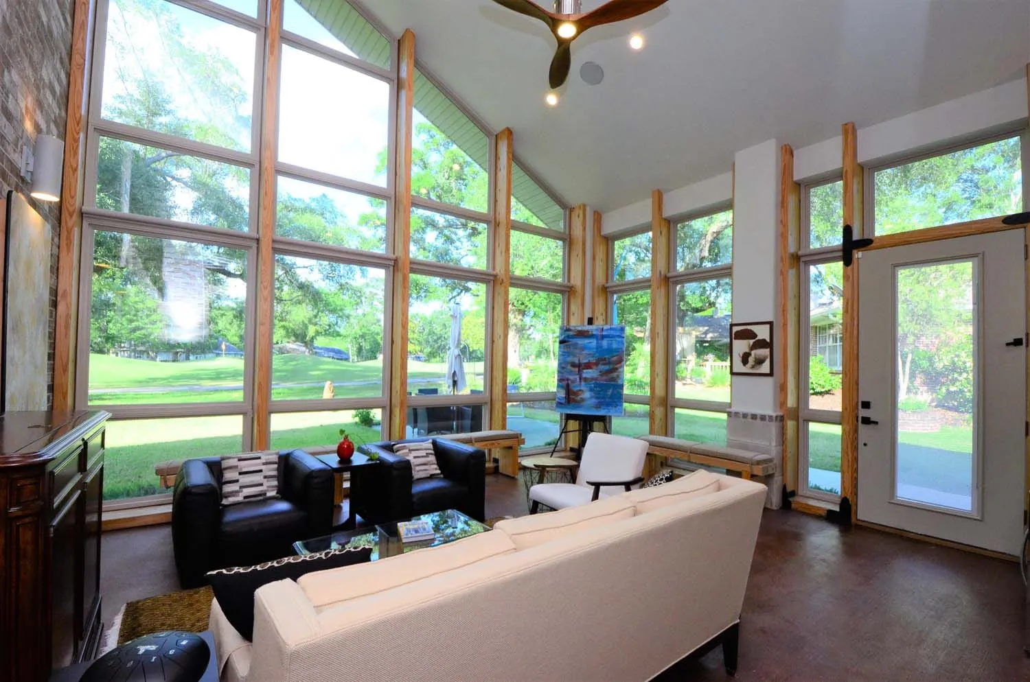 Great room with floor-to-ceiling windows overlooking the lawn