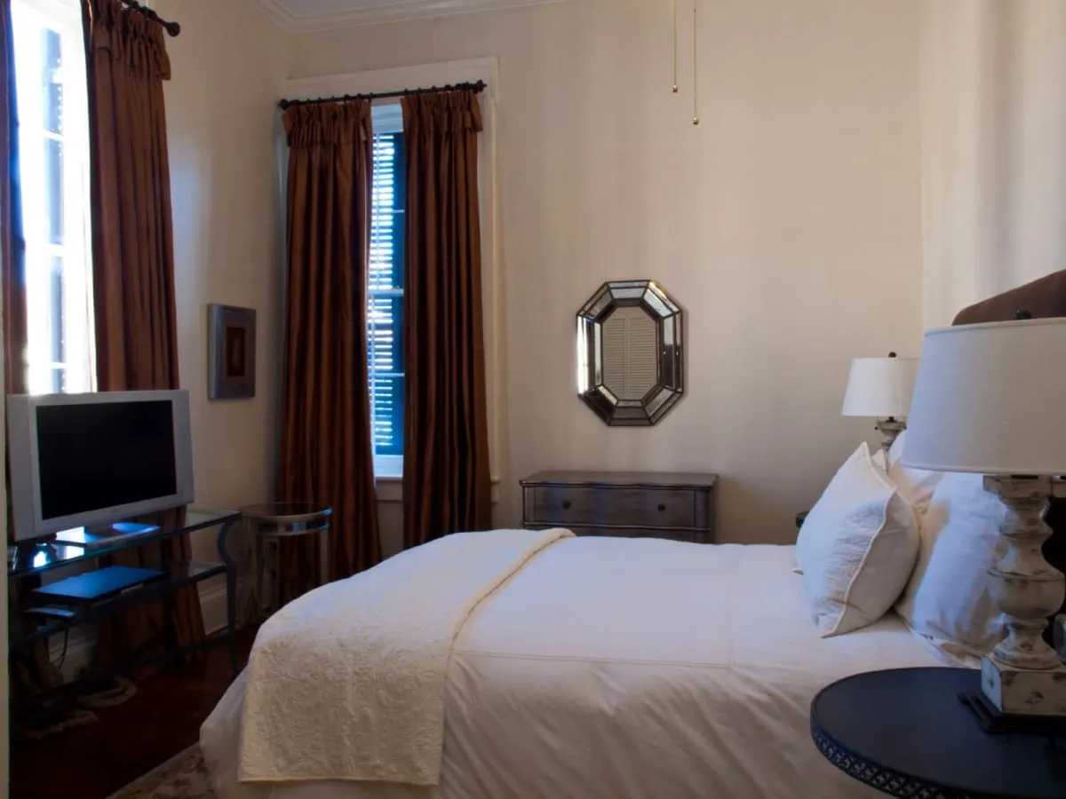 Second queen bedroom with flat-screen TV and curtained windows