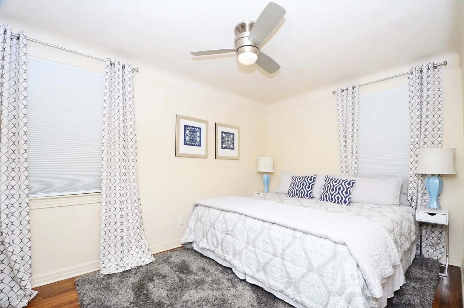 Bedroom with bed, ceiling fan and gray rug