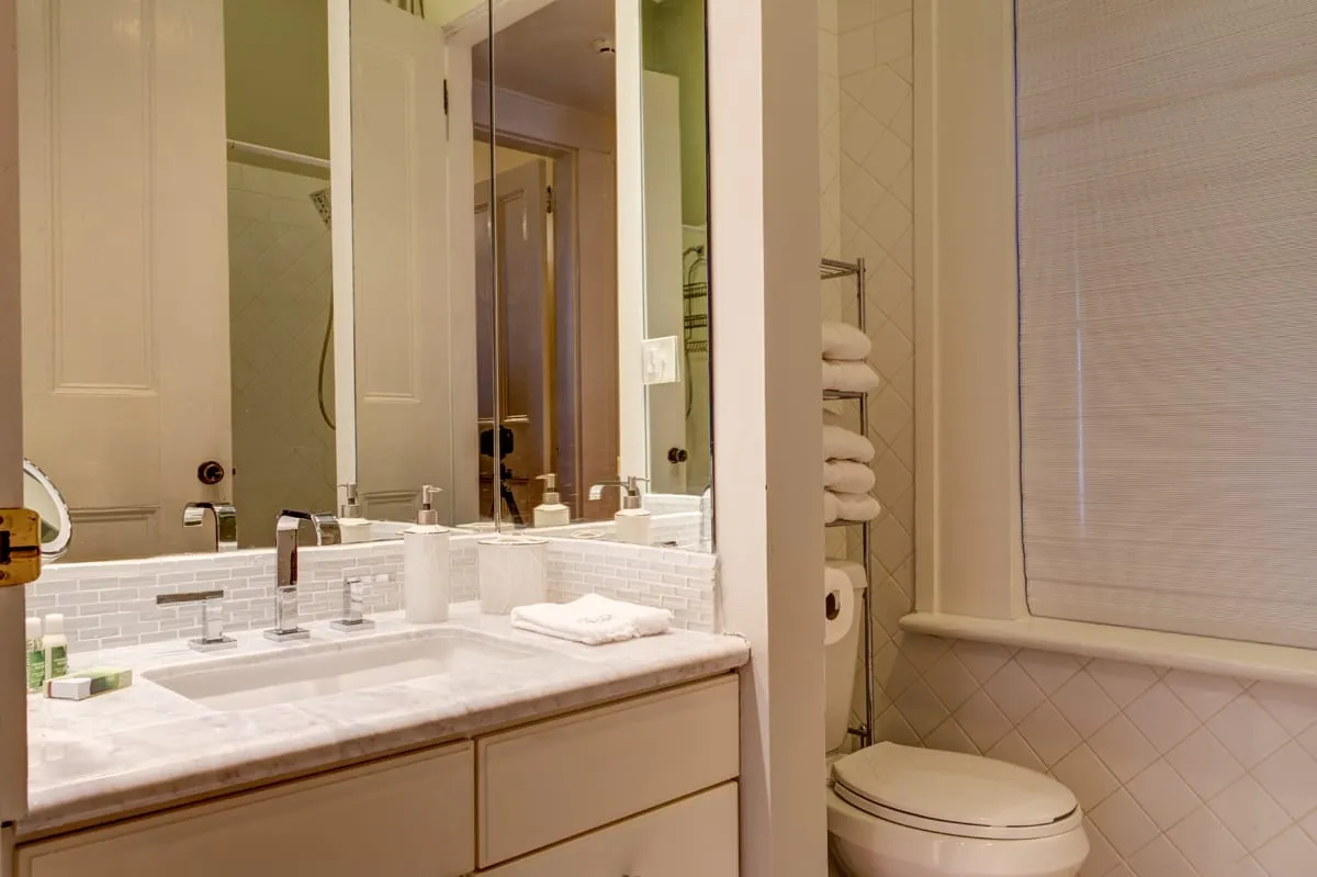 Bathroom vanity with marble counter and large mirror