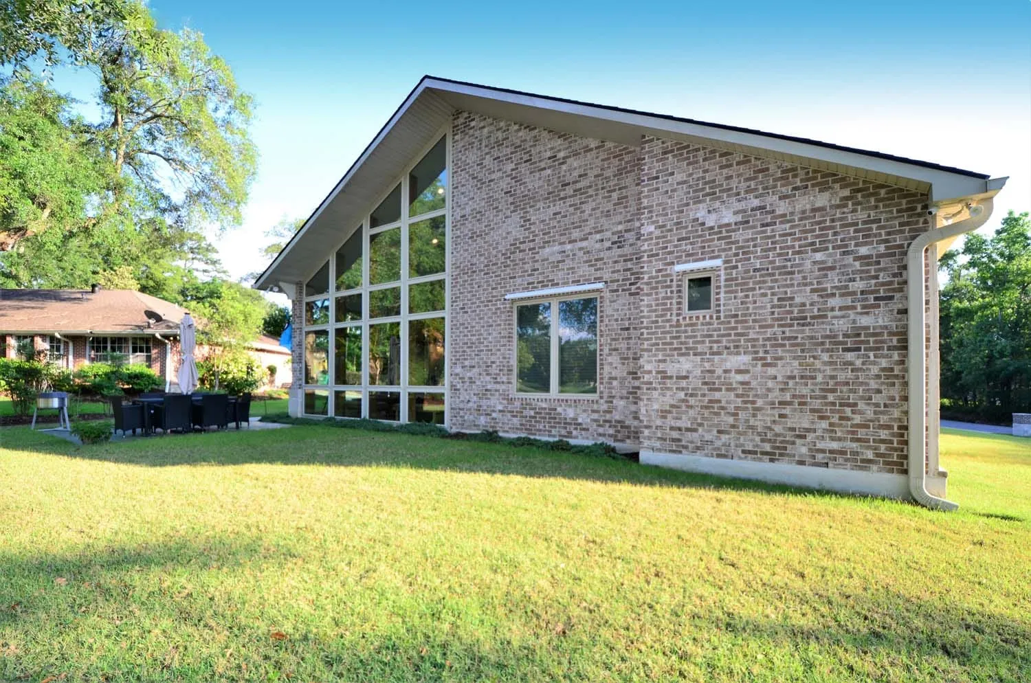 Rear exterior with a wall of windows and wide lawn