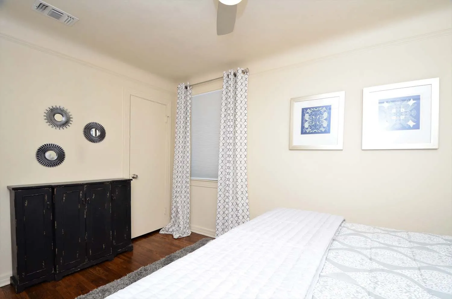Bedroom with dresser and framed prints