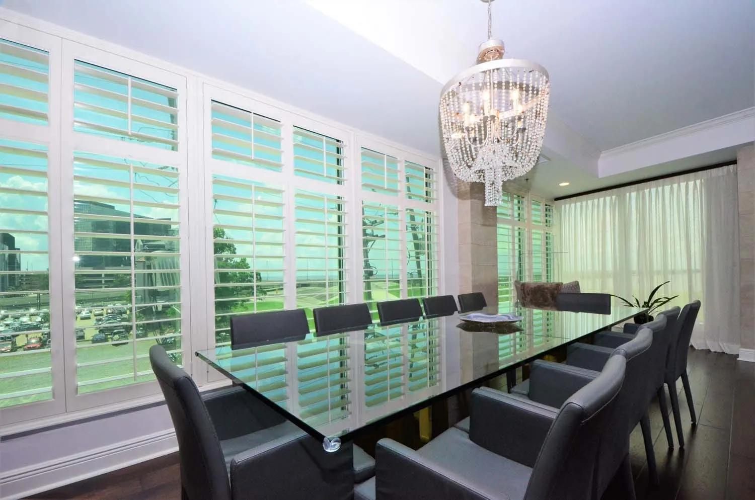 Dining room with black table, chandelier and shuttered windows