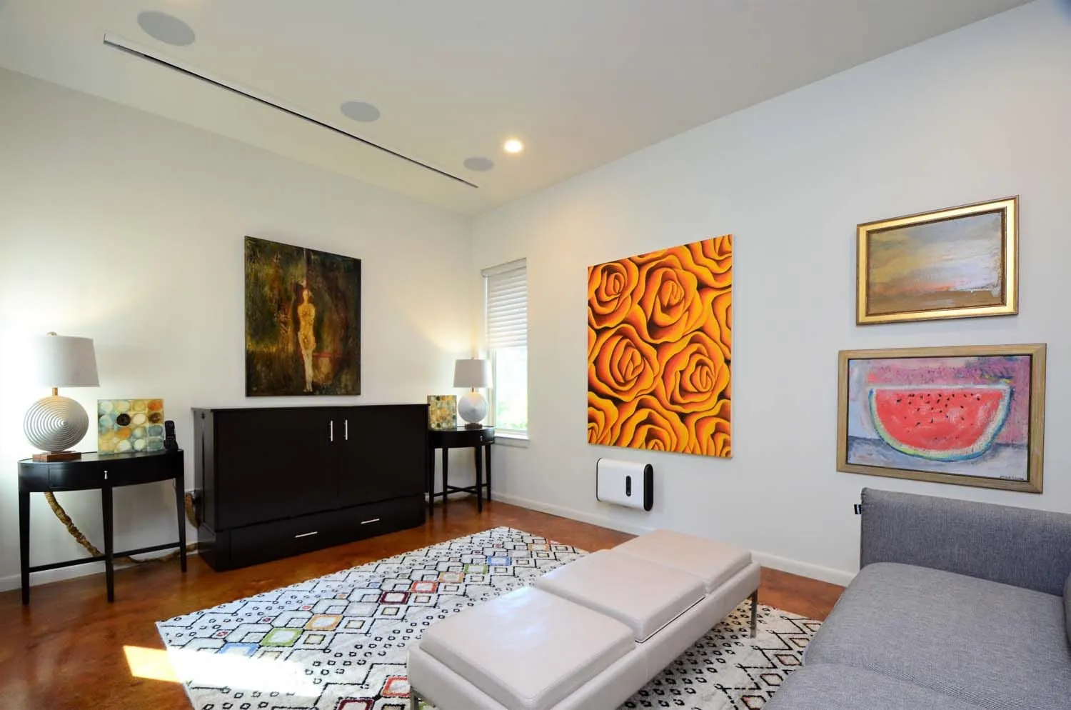 Media wall with paintings and patterned rug