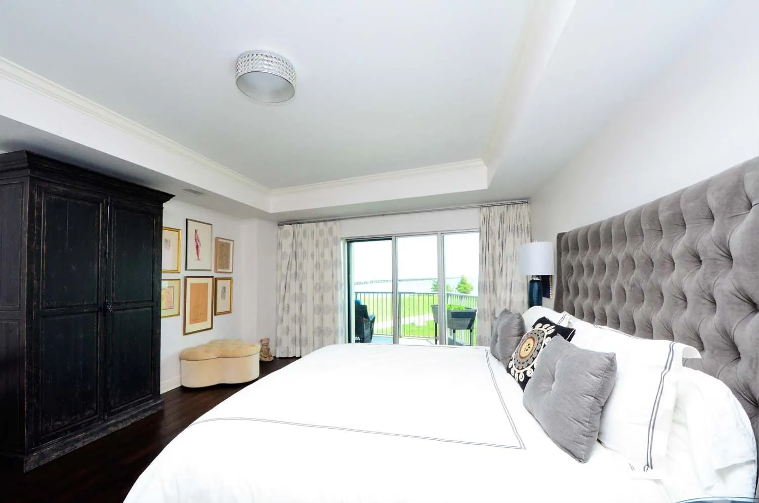 Bedroom with tall tufted headboard and balcony access