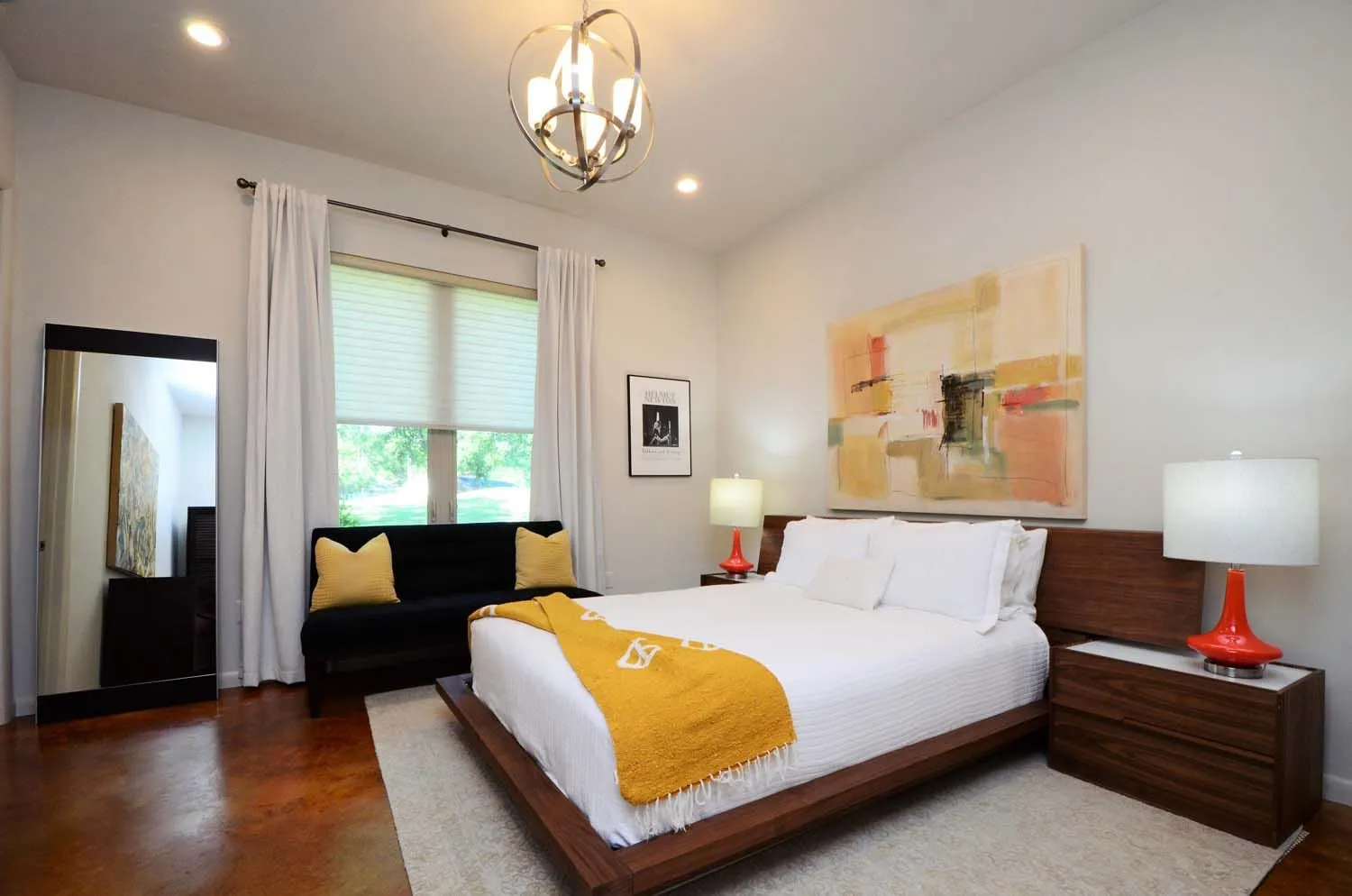 Bedroom with queen bed, chandelier and abstract painting