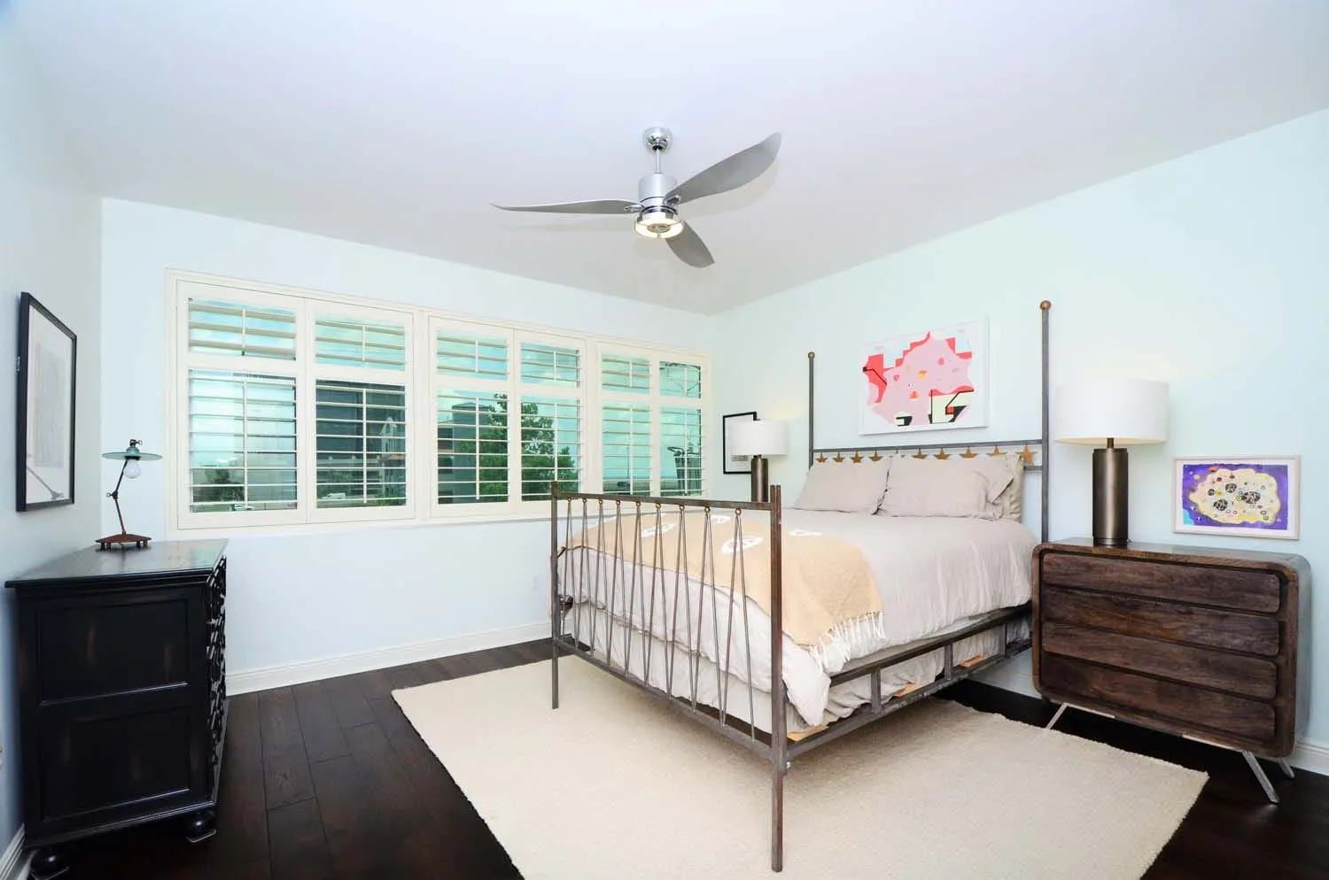 Guest bedroom with metal-frame bed and ceiling fan