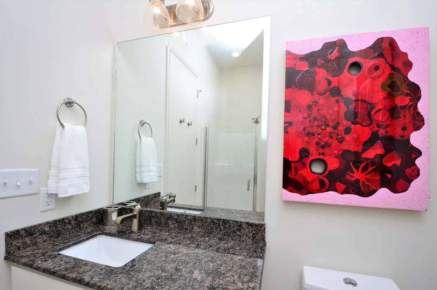 Bathroom with glass shower and red abstract painting