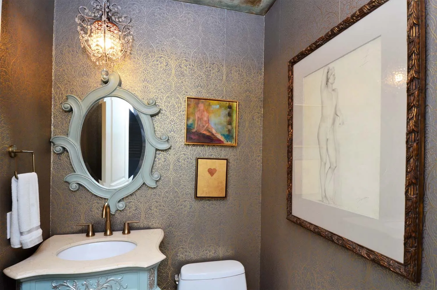 Powder room with ornate oval mirror and framed art