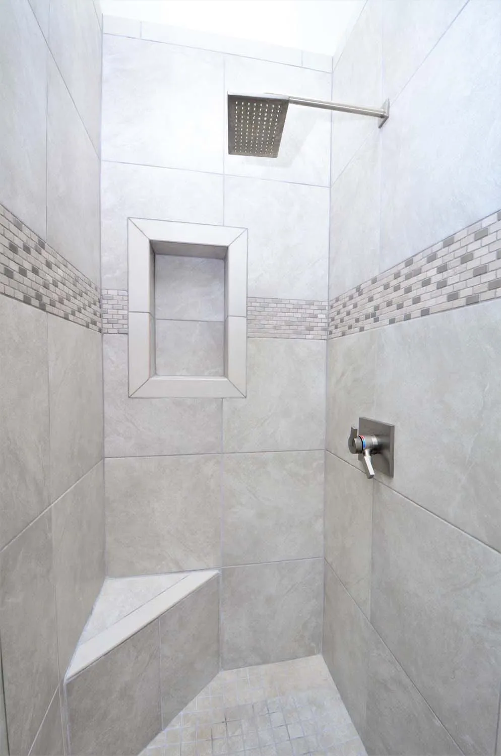 Walk-in tiled shower with mosaic accent band